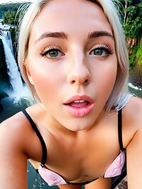 platinum blonde at Iguazu Falls edge her tanned skin glowing in the pre dawn light